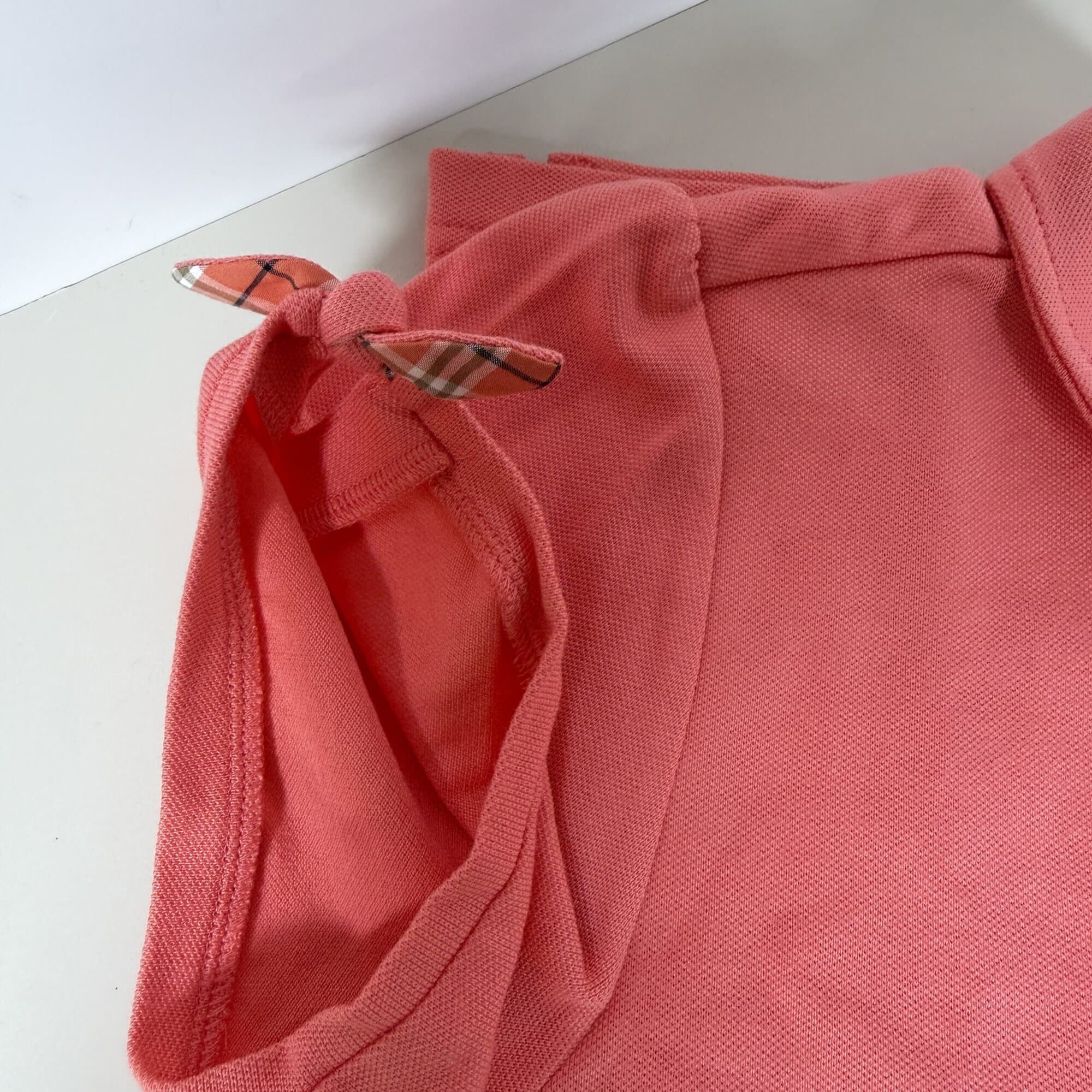 Detail of sleeve cuff with knotted tie showing Nova check trim lining
