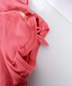 Close-up of short sleeve cuff featuring slit opening and house check tie accent