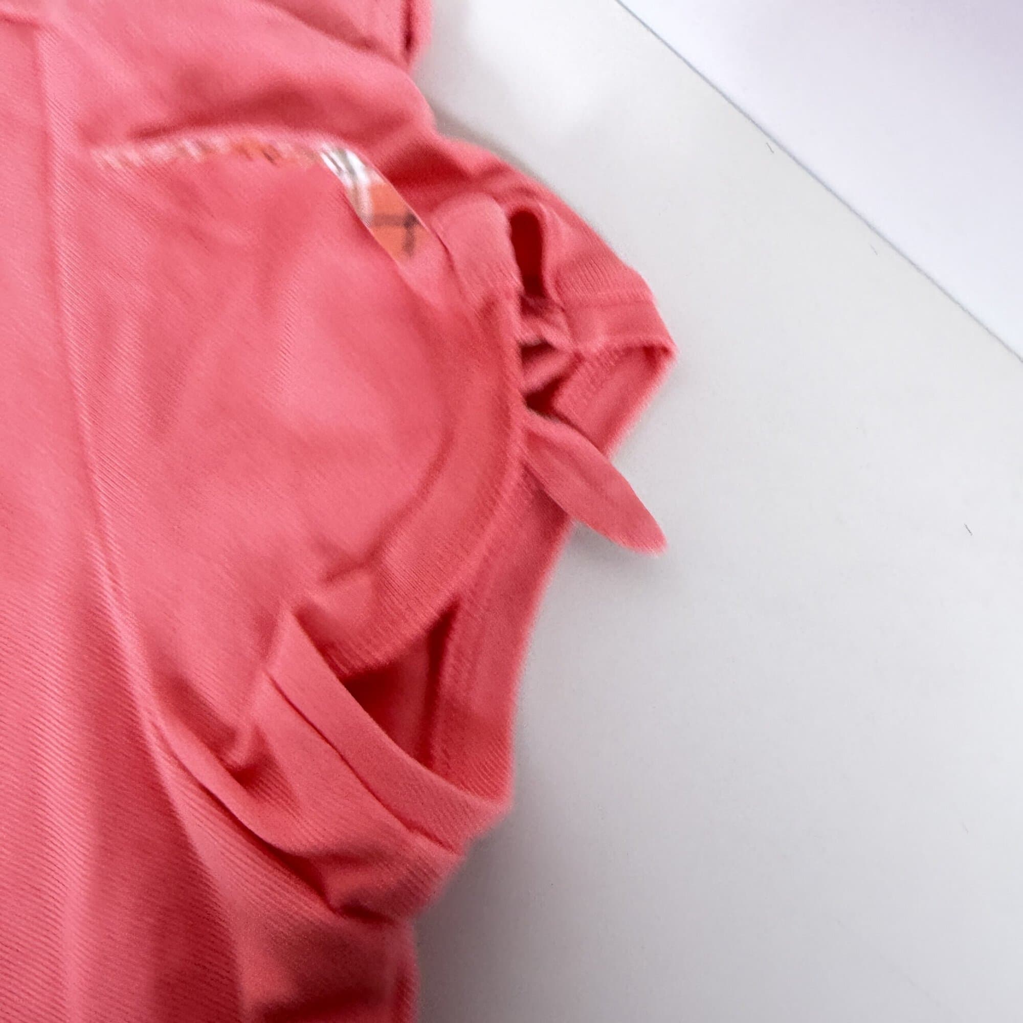 Close-up of short sleeve cuff featuring slit opening and house check tie accent