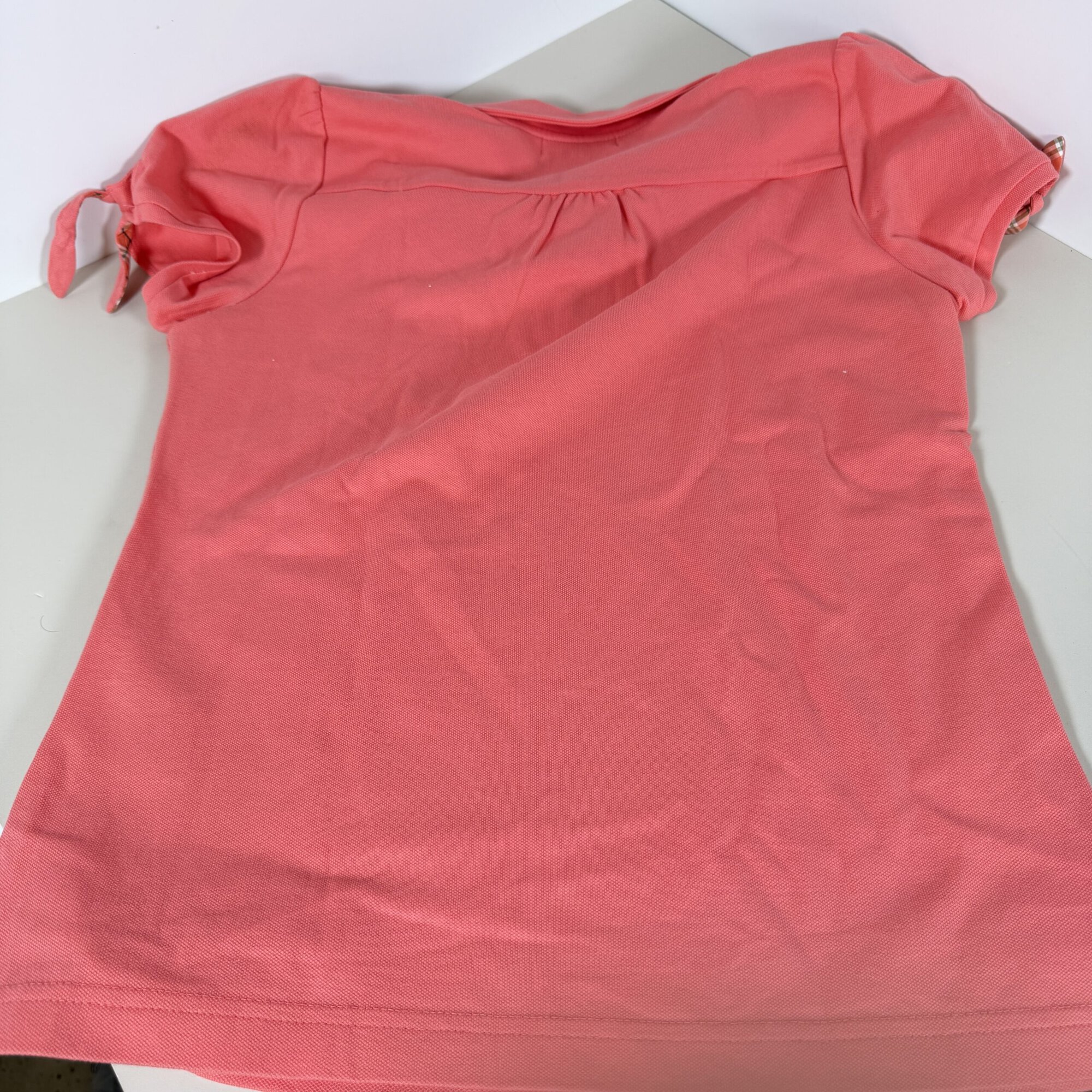 Back view of coral Burberry polo shirt showing gathered back yoke and sleeve ties