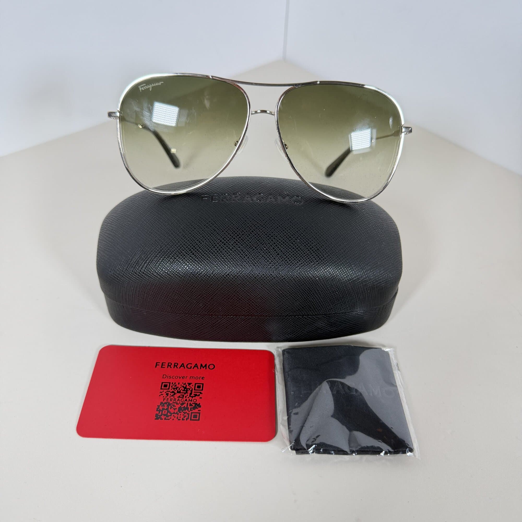 Ferragamo SF268S sunglasses shown with Ferragamo case, wrapped cleaning cloth, and brand card