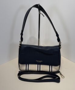 Kate Spade navy leather and striped canvas flap crossbody bag with handle and strap on display stand.