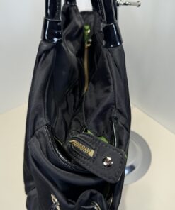 Top side angle showing zipper closure, snap tab, and patent handle attachment
